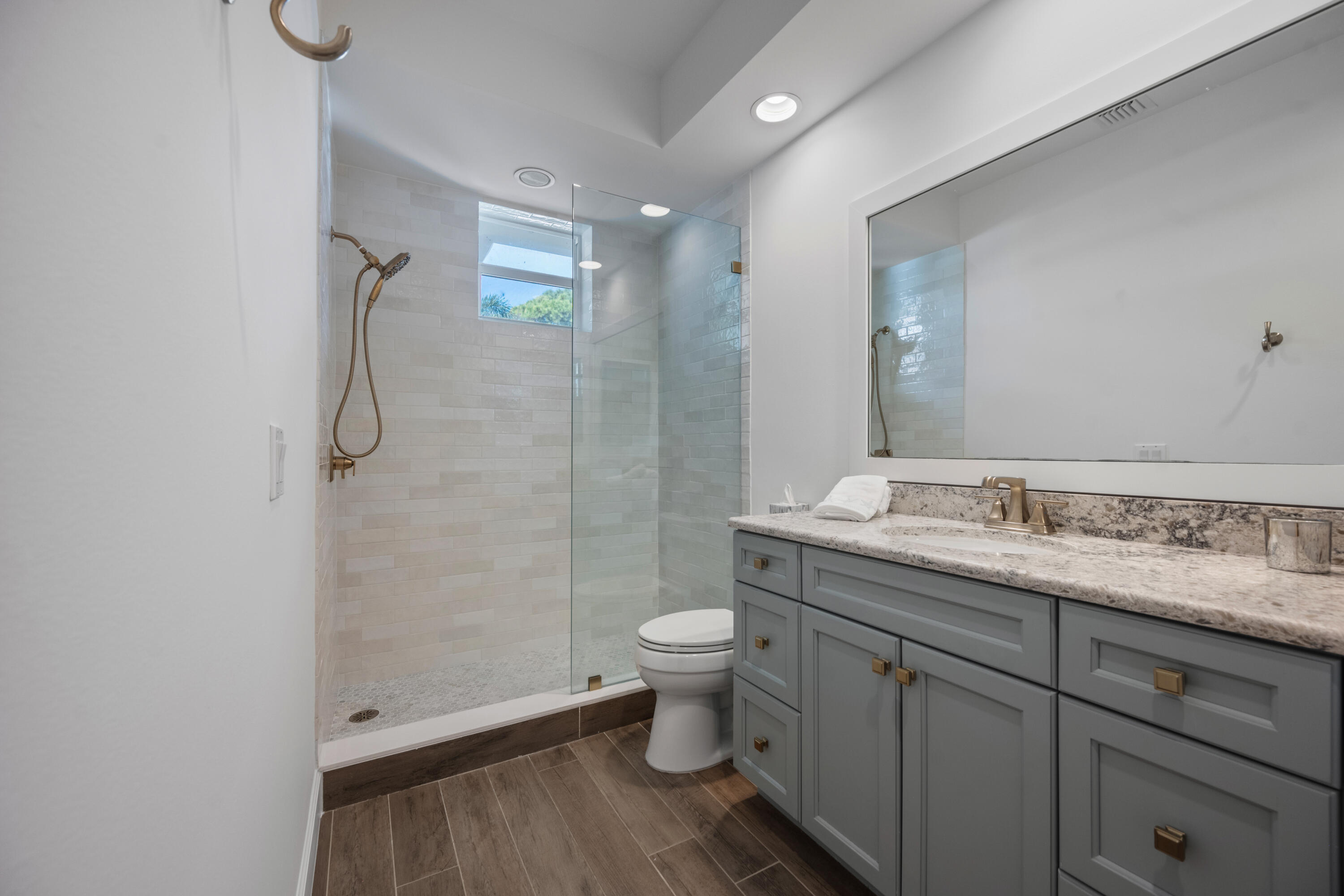 106 Toteka Circle Jupiter, FL 33458 - Photo 14 of 27 a bathroom with a granite countertop sink a toilet and shower