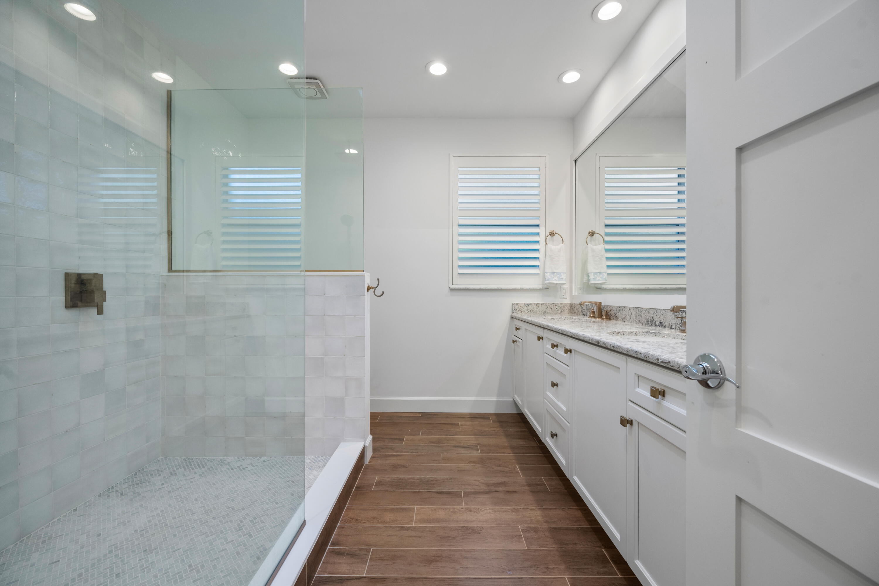 106 Toteka Circle Jupiter, FL 33458 - Photo 17 of 27 a bathroom with a granite countertop sink a toilet a mirror and a shower