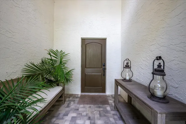 a view of a hallway with entryway and potted plants
