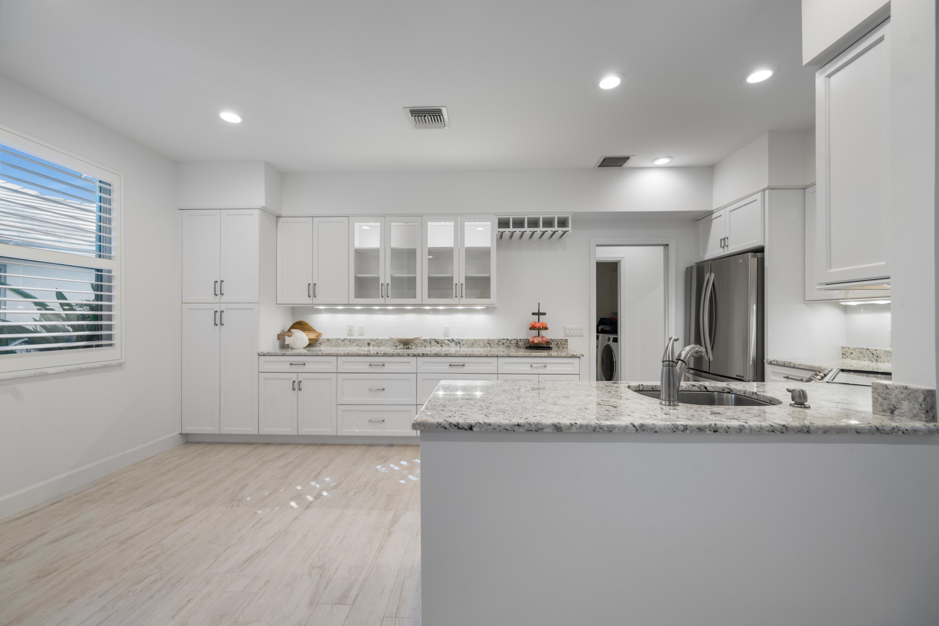 106 Toteka Circle Jupiter, FL 33458 - Photo 8 of 27 a large kitchen with granite countertop a sink and white cabinets