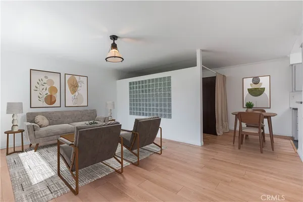 a living room with furniture wooden floor and a window