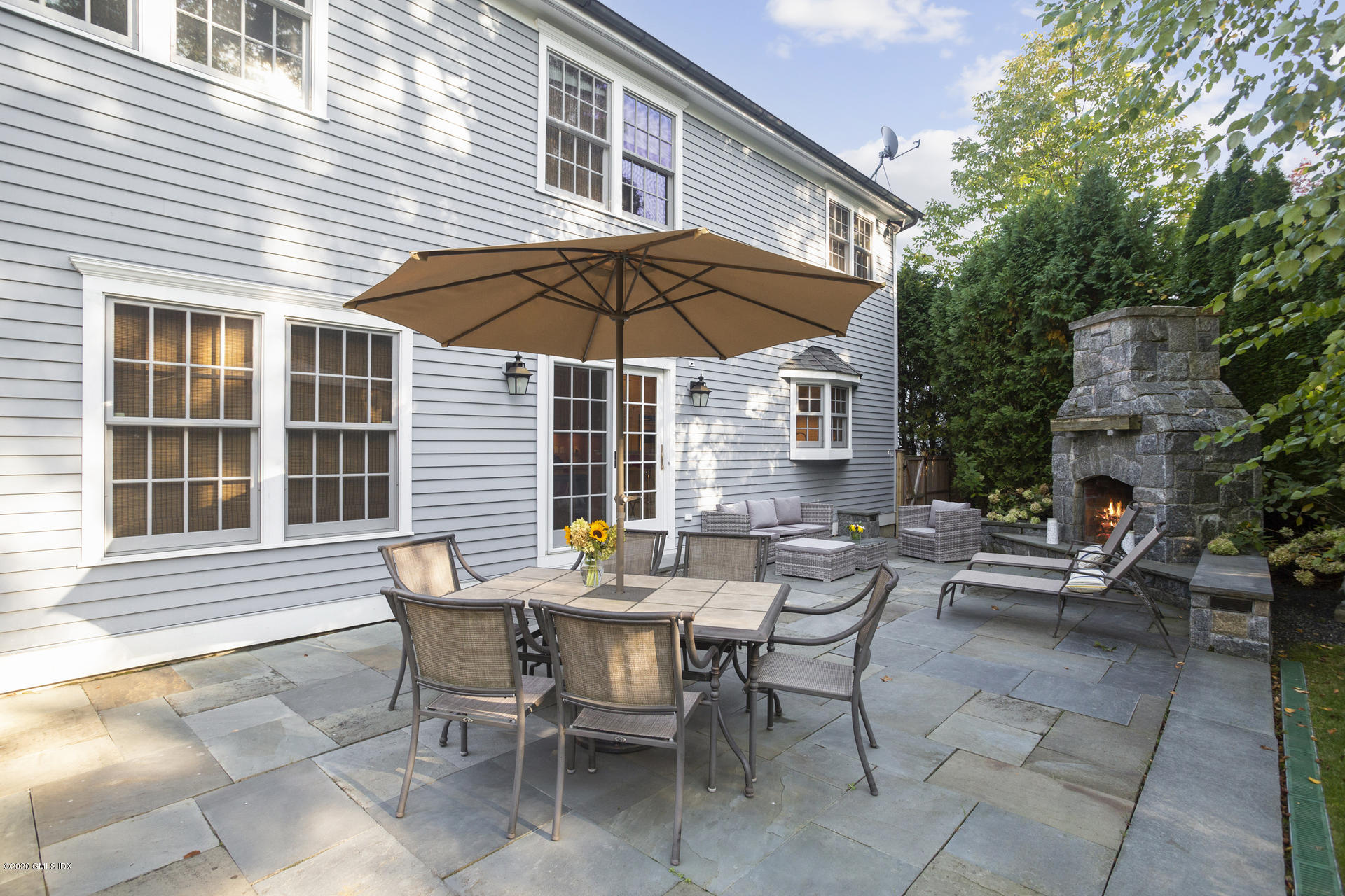 40 Riverside Lane Riverside, CT 06878 - Photo 39 of 45 a view of a house with a table and chair under an umbrella