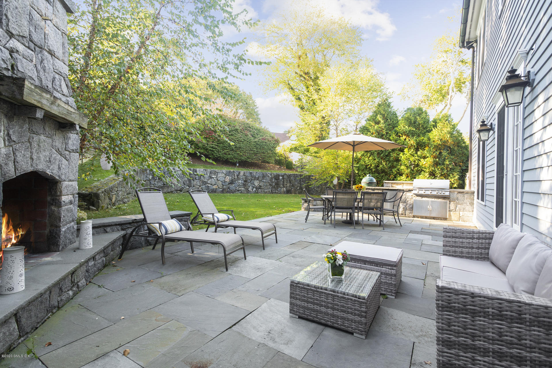 40 Riverside Lane Riverside, CT 06878 - Photo 4 of 45 a view of a patio with couches chairs and a fire pit and two large trees