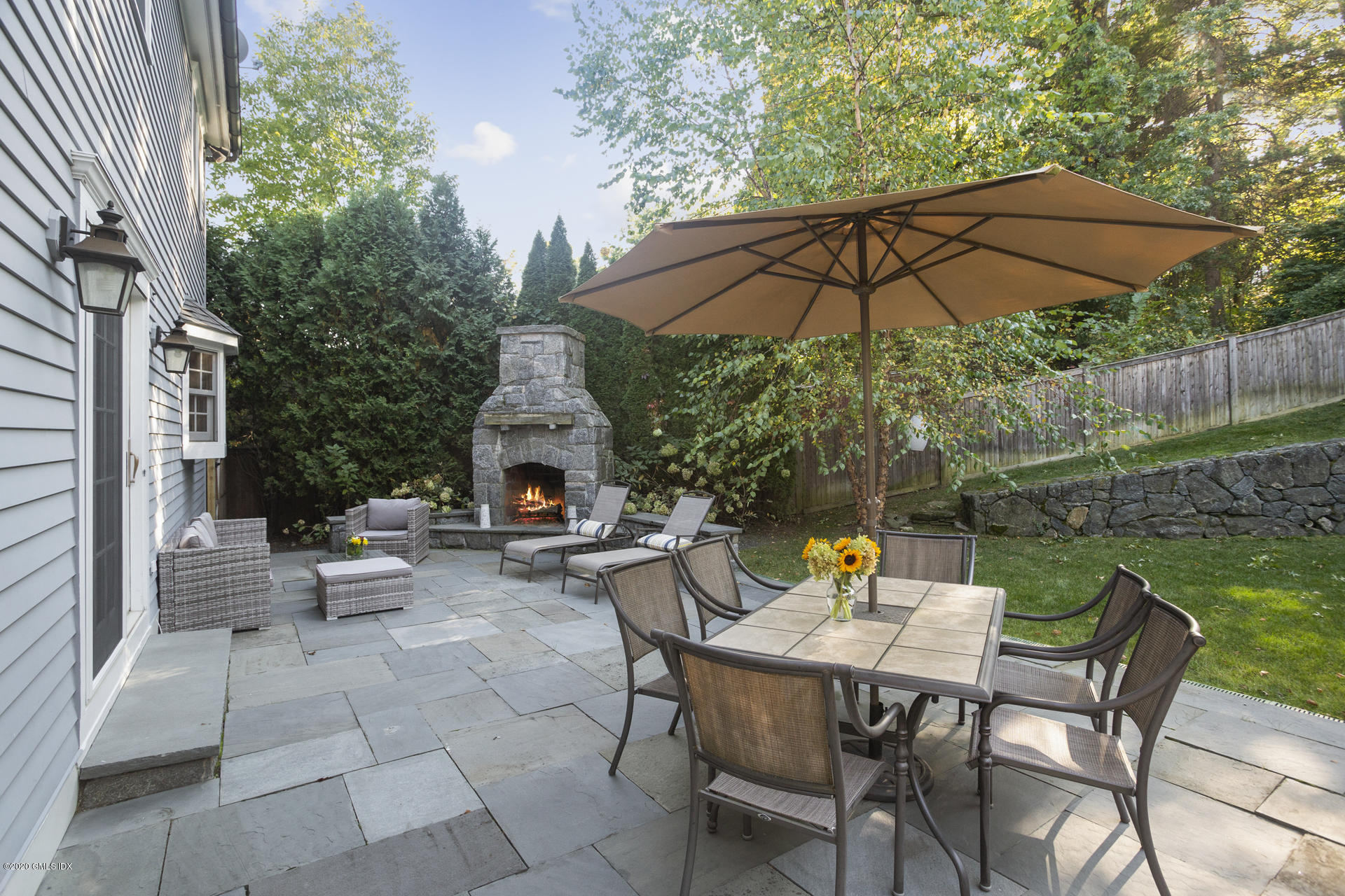 40 Riverside Lane Riverside, CT 06878 - Photo 5 of 45 a view of a patio with a table and chairs under an umbrella