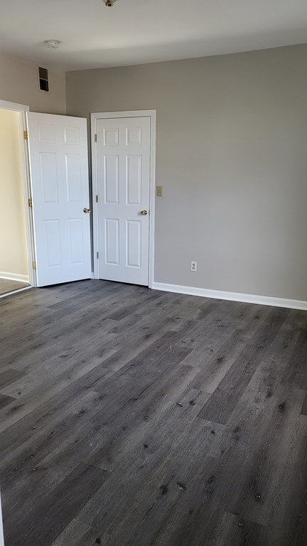 124 Stevens Street, Unit 3 Lowell, MA 01851 - Photo 16 of 18 a view of an empty room with wooden floor
