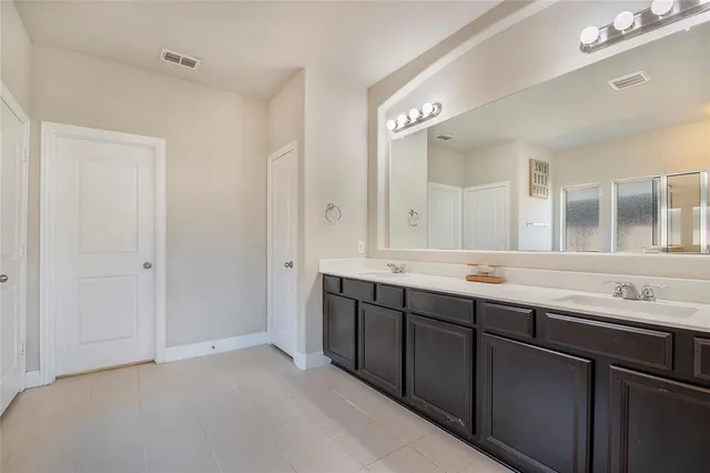 a spacious bathroom with a tub sink and mirror