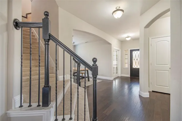 a view of a hallway with wooden floor and stairs