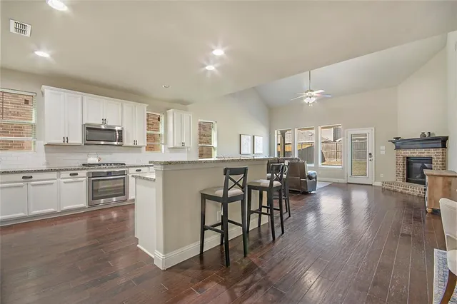 a kitchen with a table chairs refrigerator and cabinets