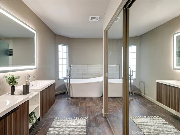 a bathroom with a tub sink and mirror