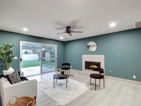 a living room with furniture a rug potted plant and a large window