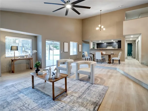 a living room with furniture and a dining table with kitchen view