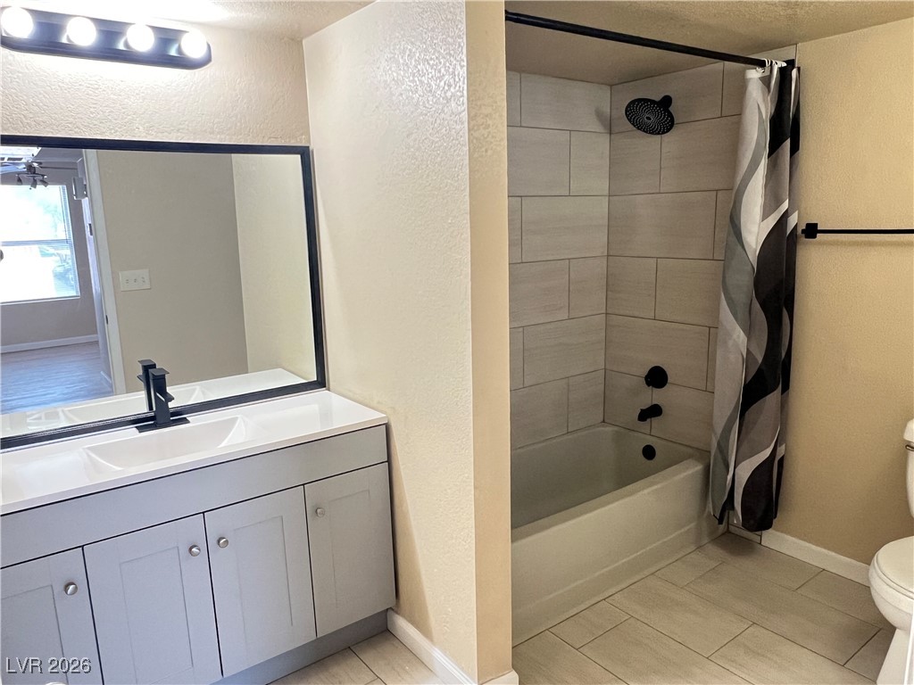 8101 West Flamingo Road, Unit 2161 Las Vegas, NV 89147 - Photo 11 of 21 Bathroom featuring a textured wall, shower / tub combo, vanity, and a textured ceiling