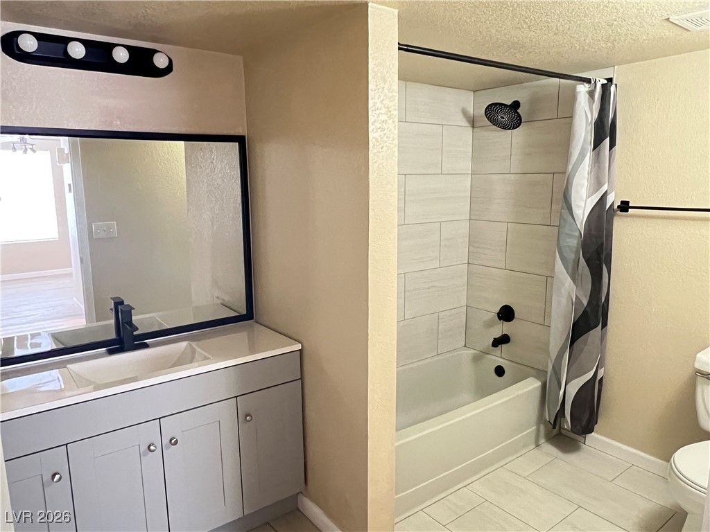 8101 West Flamingo Road, Unit 2161 Las Vegas, NV 89147 - Photo 12 of 21 Bathroom with a textured ceiling, shower / tub combo, vanity, a textured wall, and light tile patterned floors