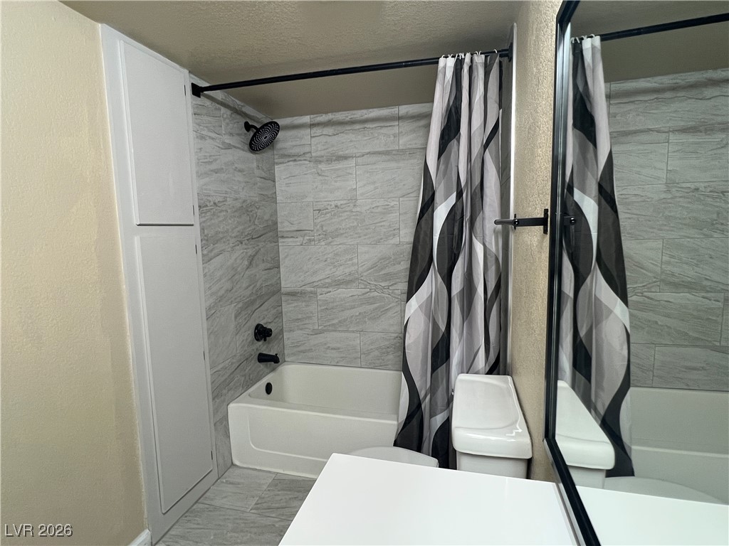 8101 West Flamingo Road, Unit 2161 Las Vegas, NV 89147 - Photo 15 of 21 Full bath featuring shower / tub combo with curtain, a textured ceiling, and vanity