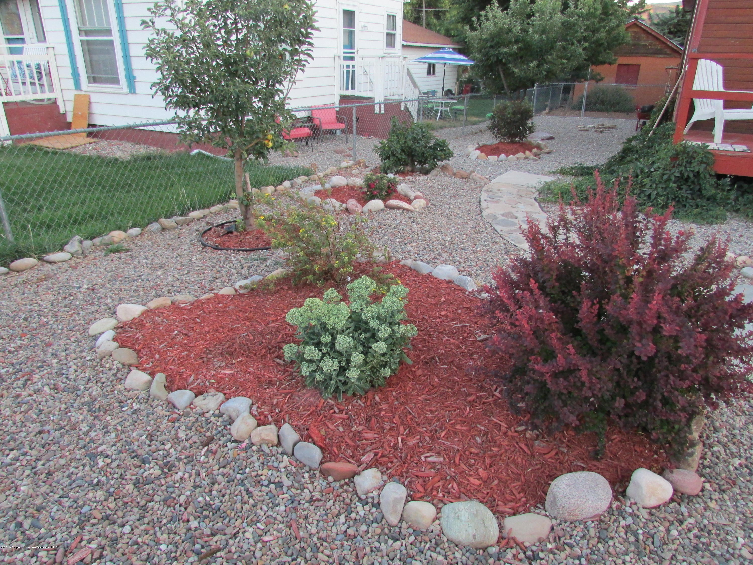819 West 3rd Street Rifle, CO 81650 - Photo 2 of 17 a view of a garden with plants and large trees
