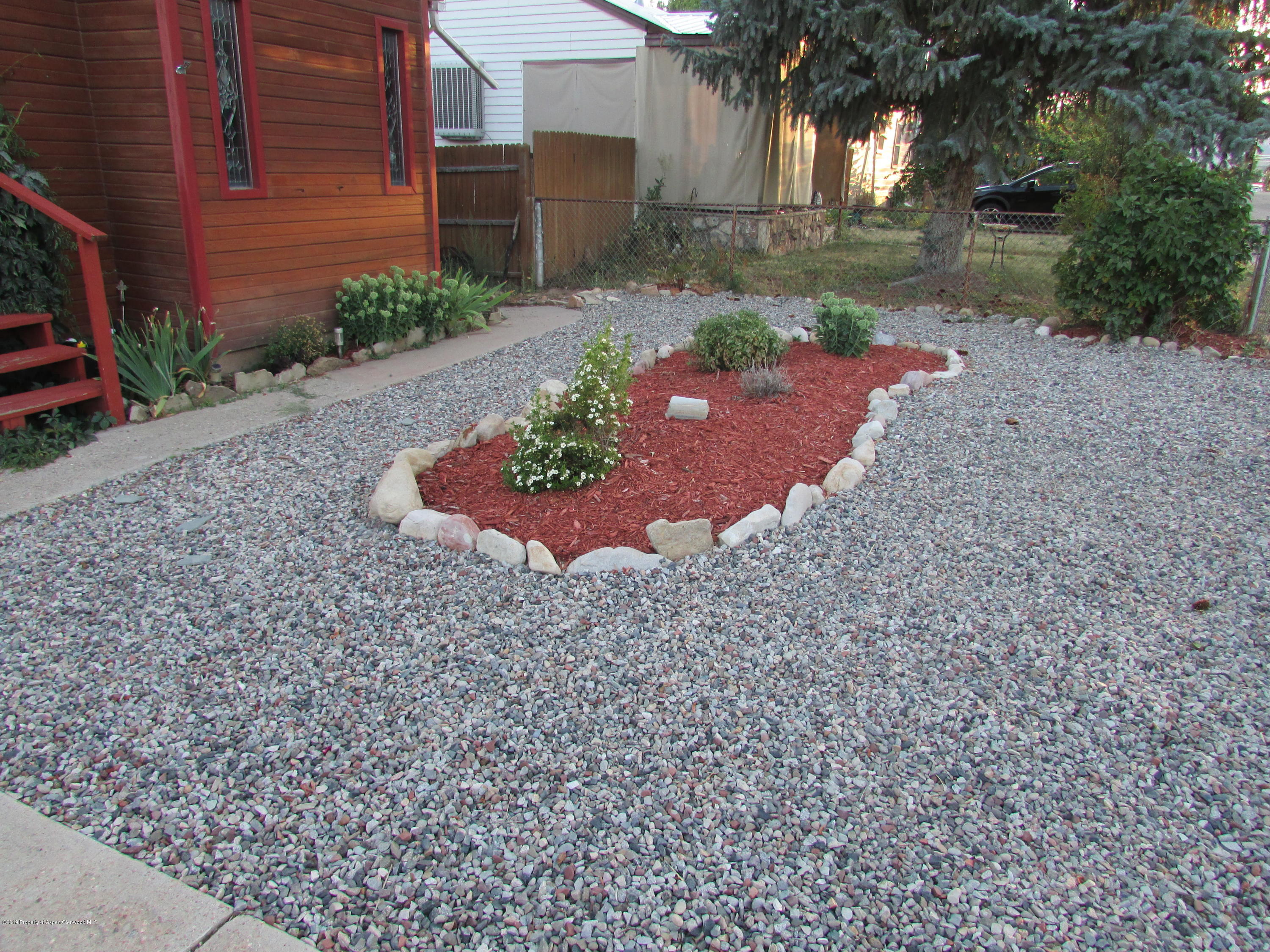 819 West 3rd Street Rifle, CO 81650 - Photo 3 of 17 a view of a garden with plants and large trees