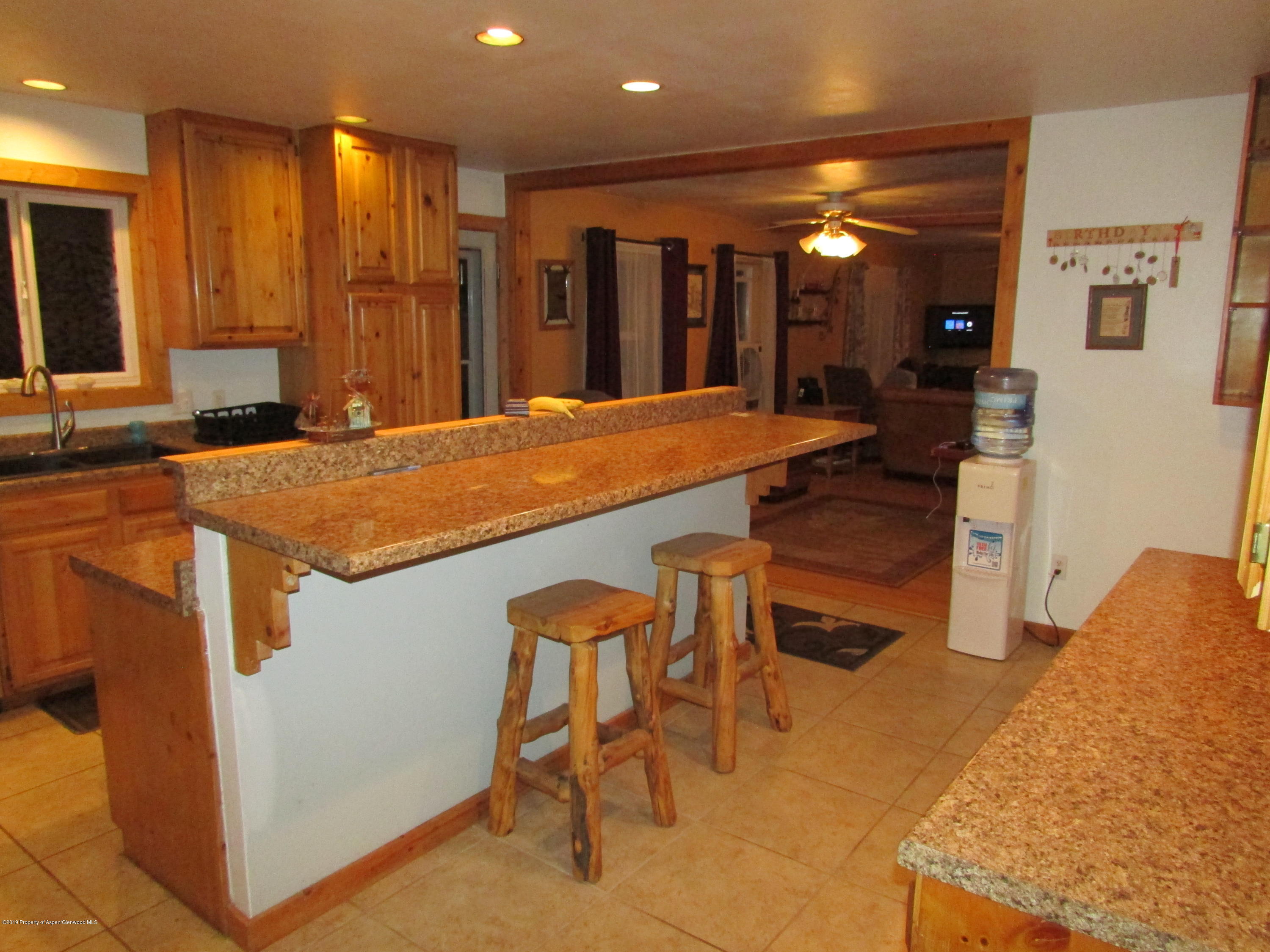 819 West 3rd Street Rifle, CO 81650 - Photo 6 of 17 a dining hall with stainless steel appliances granite countertop furniture a sink a refrigerator and a counter top