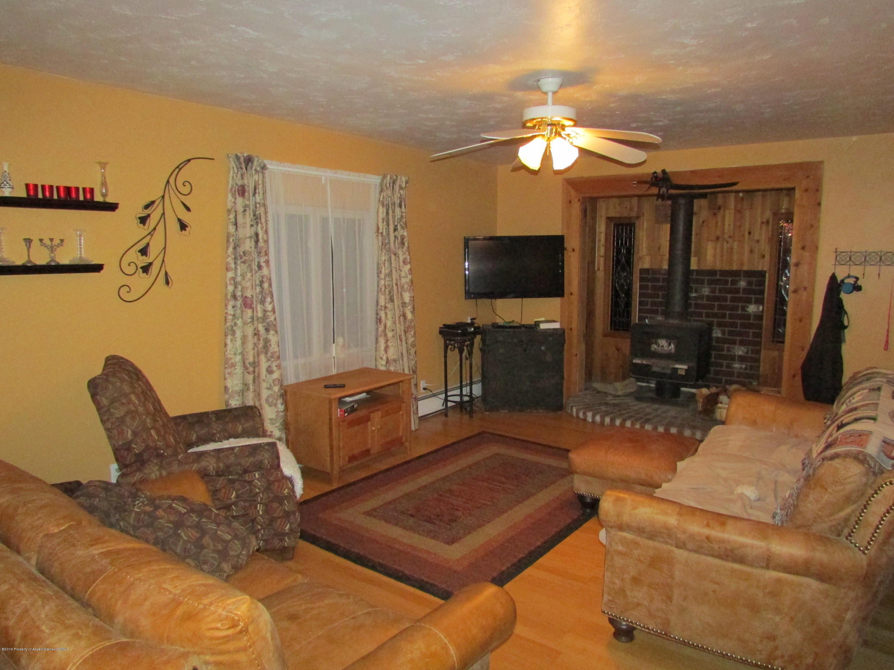 819 West 3rd Street Rifle, CO 81650 - Photo 8 of 17 a living room with furniture a flat screen tv and a fireplace