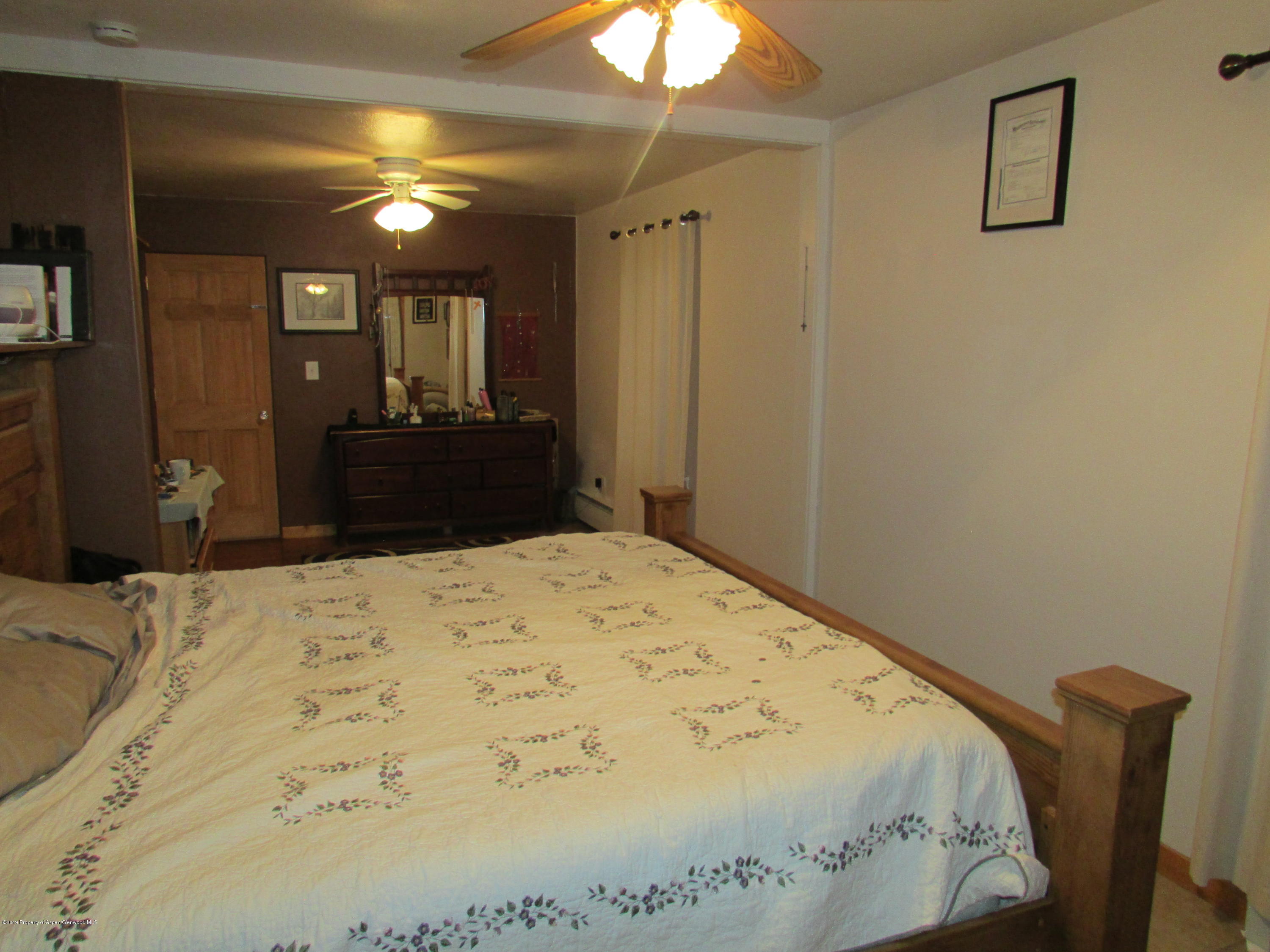 819 West 3rd Street Rifle, CO 81650 - Photo 9 of 17 a bedroom with a bed and a chandelier