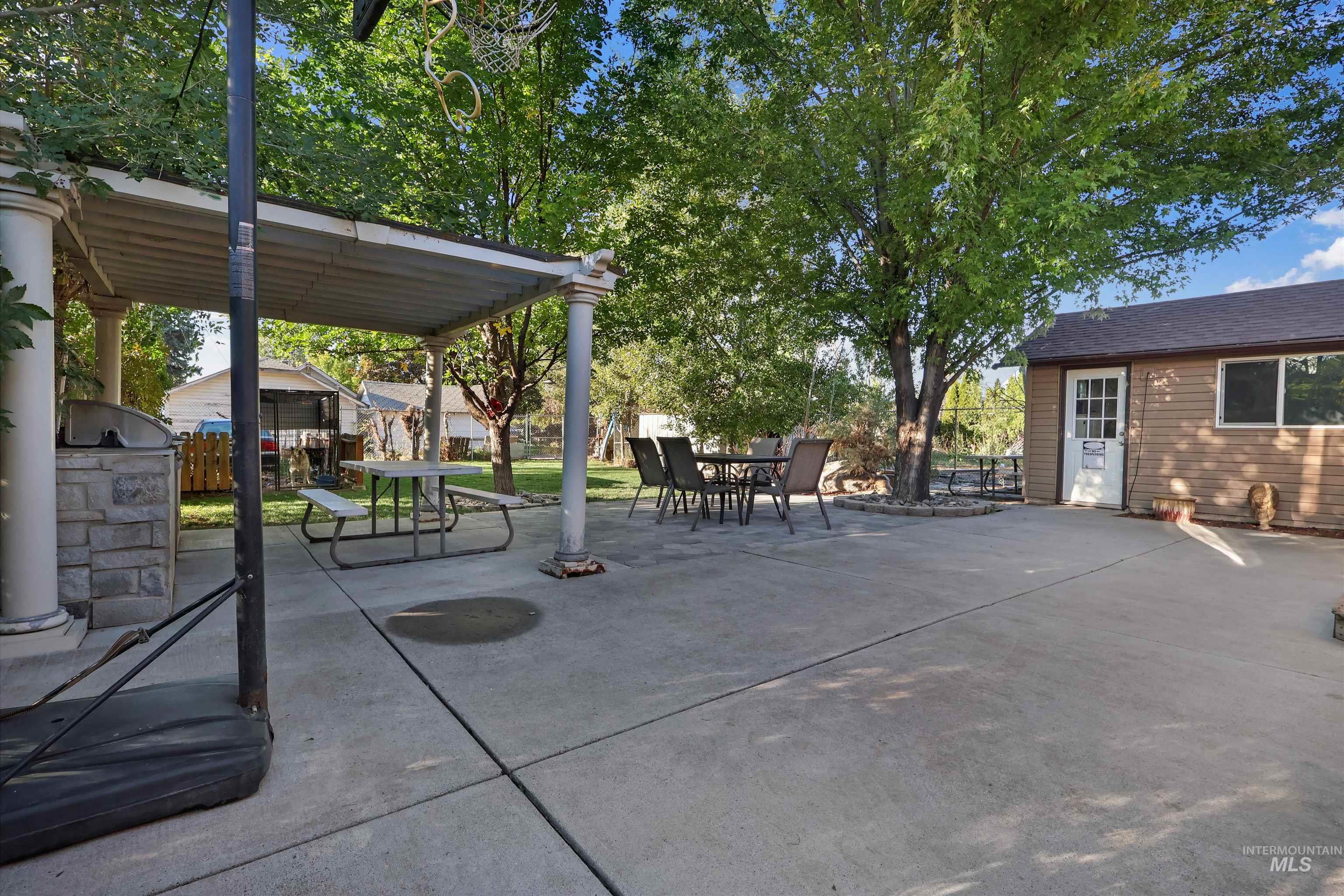 1009 9th Street Rupert, ID 83350 - Photo 20 of 28 Expansive concrete patio with a covered pergola featuring decorative columns