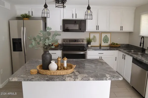 a kitchen with a stove a microwave a refrigerator and cabinets