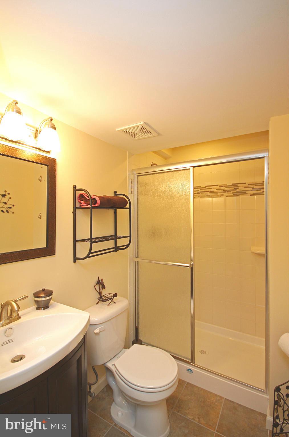 7707 Mahogany Road Severn, MD 21144 - Photo 23 of 30 a bathroom with a sink a toilet and shower