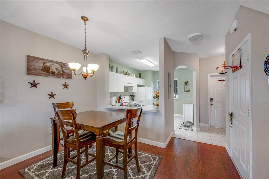 5921 Riverside Avenue Tamarac, FL 33321 - Photo 12 of 22 a view of a dining room and a livingroom with furniture wooden floor a chandelier
