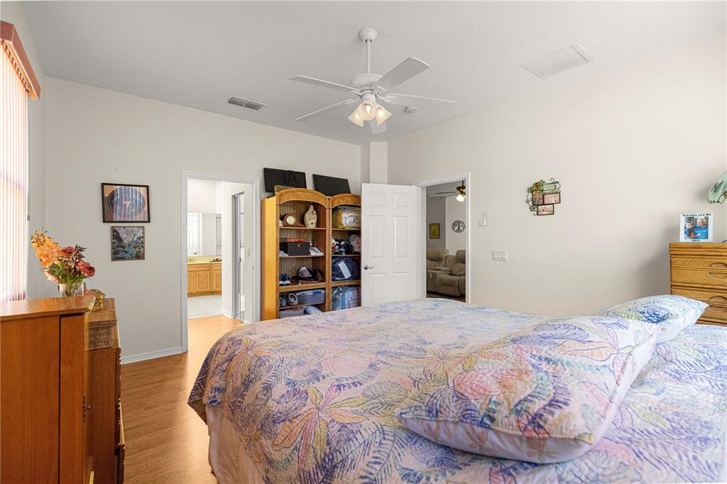 9250 Southwest 96th Court Road Ocala, FL 34481 - Photo 24 of 46 a bedroom with a large bed and a chandelier