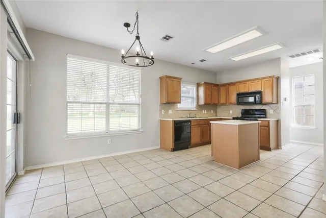 a kitchen with a sink a counter top space cabinets and stainless steel appliances