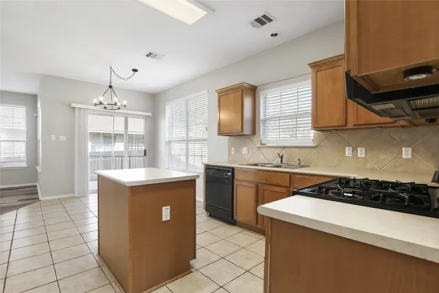 a kitchen with kitchen island stainless steel appliances a sink stove and cabinets