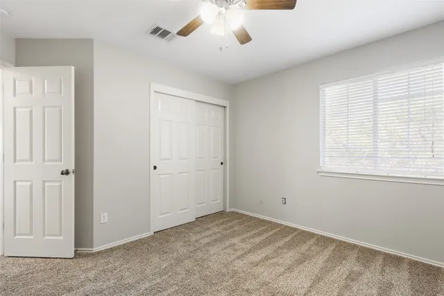 a view of a livingroom with a ceiling fan and window