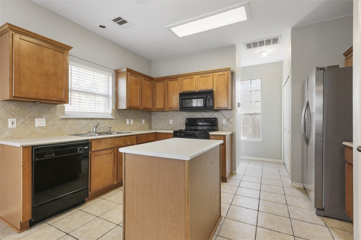 9405 Billingham Trail Austin, TX 78717 - Photo 4 of 40 a kitchen with a stove a sink and a refrigerator