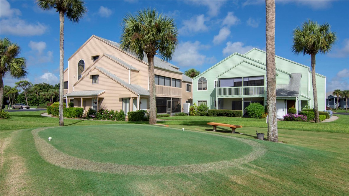 9632 Riverside Drive, Unit 2 Sebastian, FL 32958 - Photo 3 of 29 a view of a white house next to a yard with big trees and plants