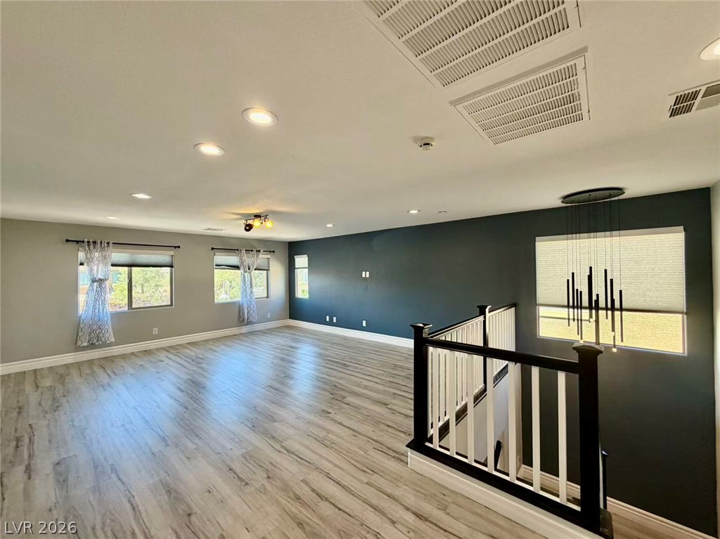 135 Tall Ruff Drive Las Vegas, NV 89148 - Photo 12 of 29 A spacious and luminous living area features light wood flooring and a modern stair railing.