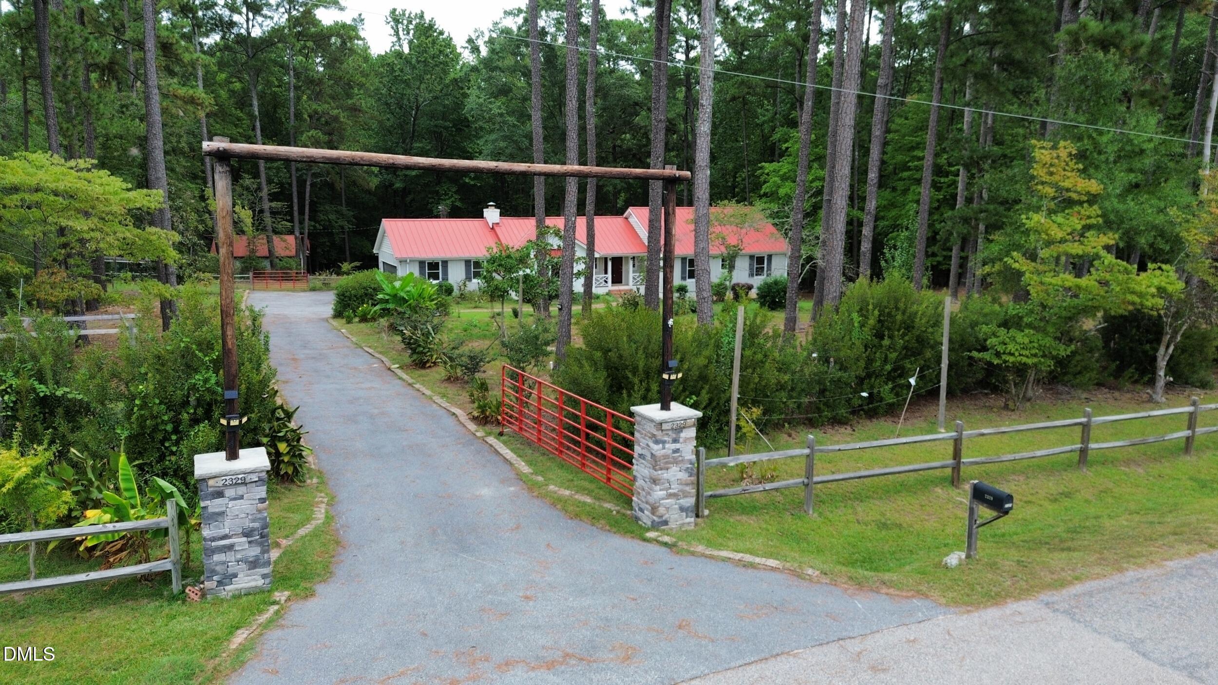 2329 Win Road Garner, NC 27529 - Photo 78 of 90 Stone-clad entry pillars featuring decorative lighting and a wood-beam archway