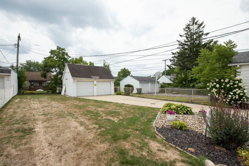 12822 Grannis Road Cleveland, OH 44125 - Photo 35 of 44 View of yard featuring a garage and an outdoor structure