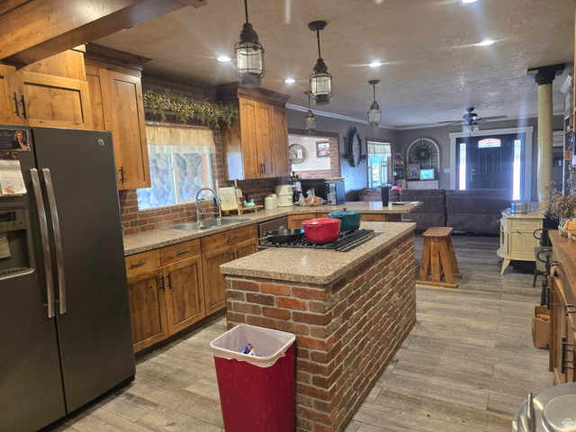 34200 Coulam Road Swan Lake, ID 83281 - Photo 7 of 24 Open-concept kitchen and living area featuring a brick island with integrated cooktop, wood-finish flooring, and recessed lighting