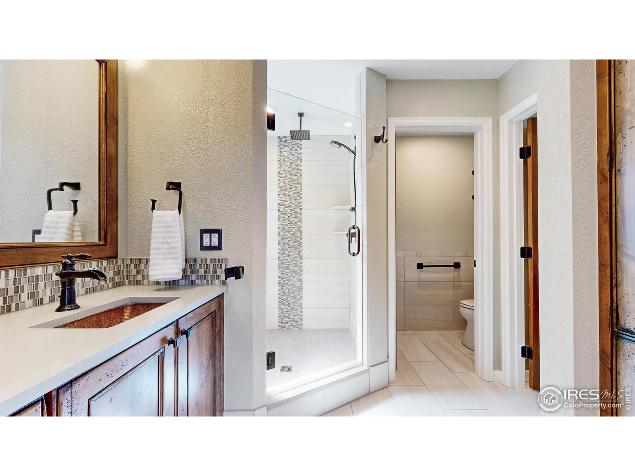 898 Eagle Ridge Court Loveland, CO 80537 - Photo 16 of 40 a bathroom with a sink a toilet and shower