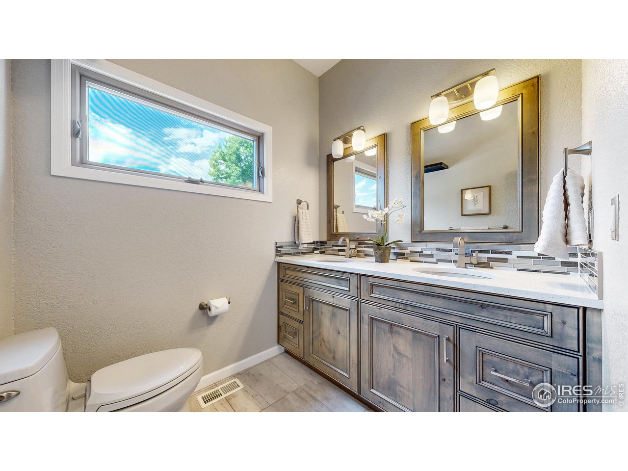 898 Eagle Ridge Court Loveland, CO 80537 - Photo 27 of 40 a bathroom with a toilet a sink and mirror