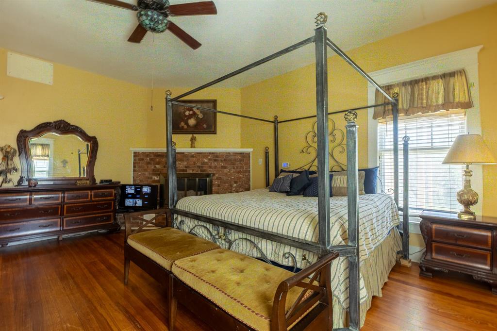 1115 Austin Street Coleman, TX 76834 - Photo 15 of 40 a bedroom with a bed and wooden floor