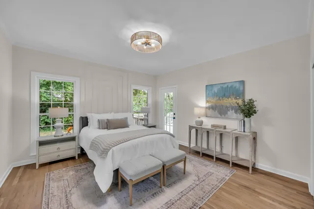a bedroom with a bed a chandelier and dresser