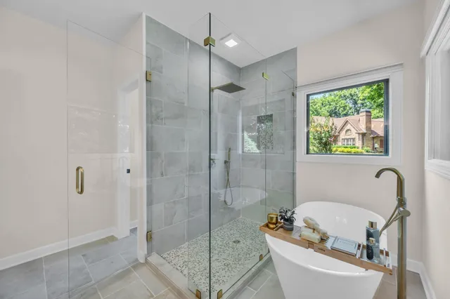 a bathroom with a tub a sink and glass door shower