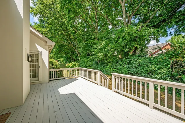 a balcony with wooden floor and trees