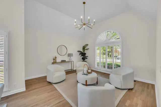 a living room with furniture chandelier and a window