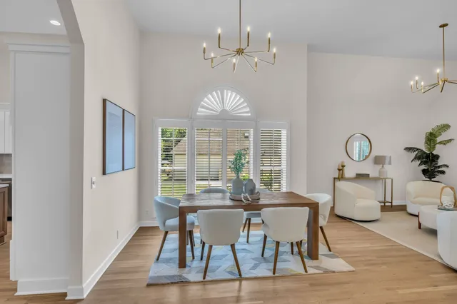a view of a dining room with furniture a chandelier and wooden floor