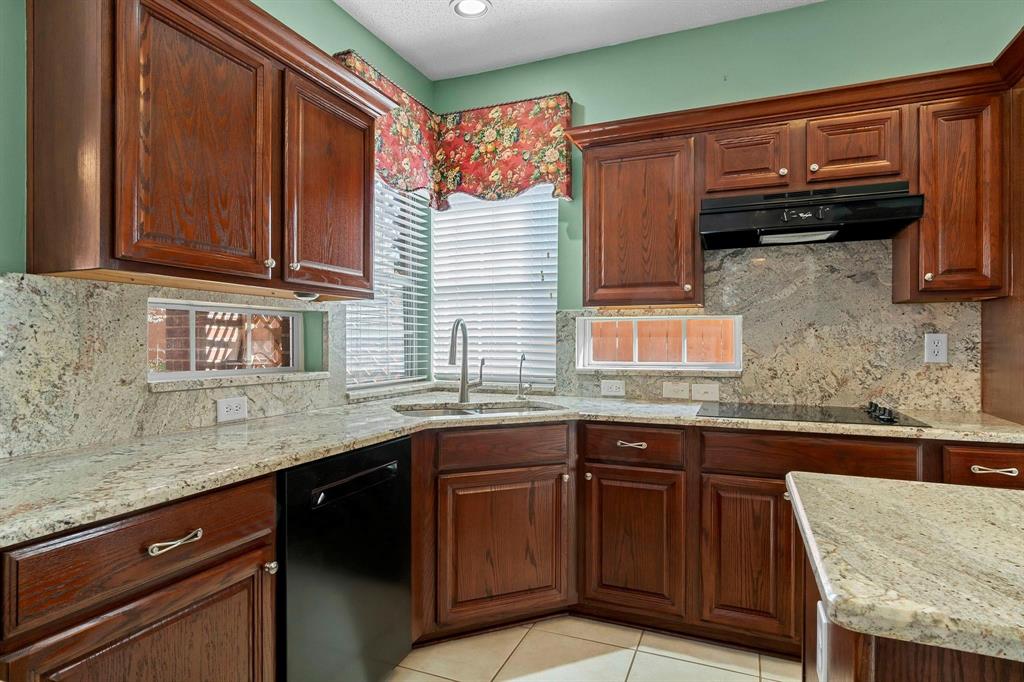 14588 Poe Court Addison, TX 75001 - Photo 10 of 28 a kitchen with stainless steel appliances granite countertop wooden cabinets a sink and dishwasher
