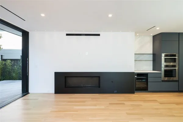 a view of an empty room with kitchen and a window