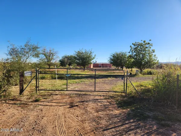 a view of a yard with wooden fence