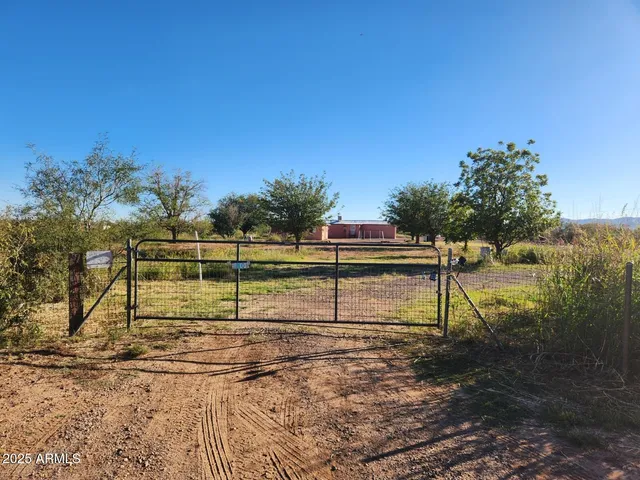 a view of a yard with wooden fence