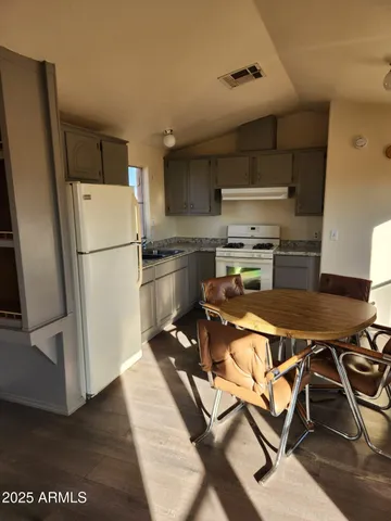 a view of an empty room with window and chandelier fan